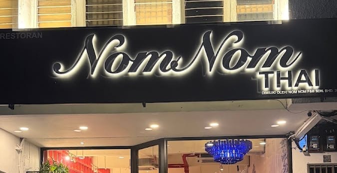 NomNom Thai at Taman Pelangi: the “NomNom THAI” signboard above the shopfront, with a blue chandelier inside
